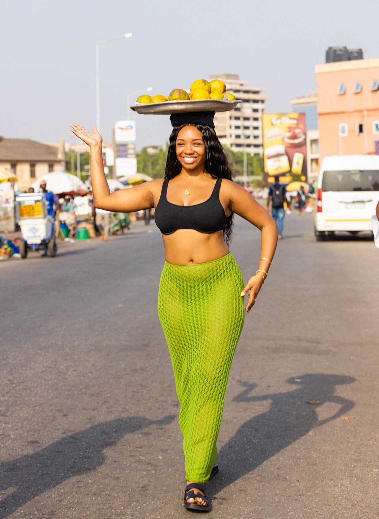 A guest smiling in a lively Accra market street